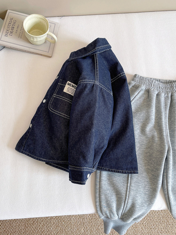 Vaikų šilto džinsinio marškinio-švarko, unisex, žiema 2025; audinys: 77.3% medvilnė, 12.9% poliesteris, 9.8% regeneruota celiuliozė; stora, vienos eilės užsegimas sagomis, be gobtuvo.