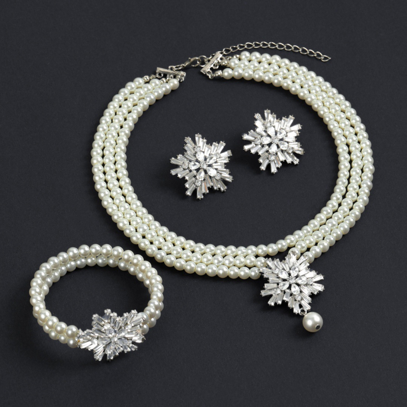 Dirbtinių perlų juvelyrinių komplektas: auskarai, karolė ir apyrankė; snaigių raštas; pakabuko medžiaga: lydinys; apdorojimo technologija: deimantas; medžiaga: dirbtinės perlai