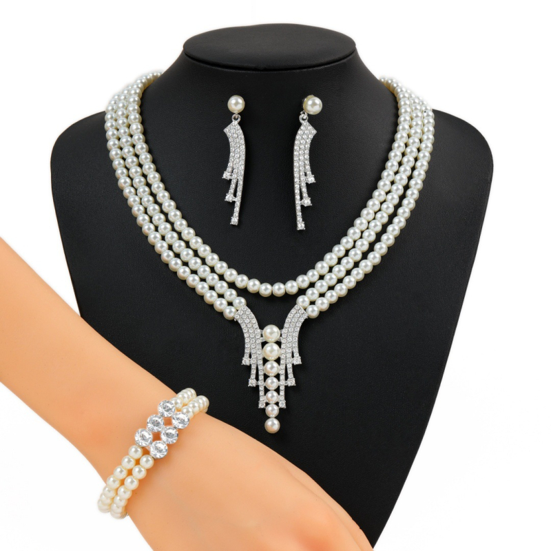 Dirbtinių perlų juvelyrinių komplektas: auskarai, karolė ir apyrankė; snaigių raštas; pakabuko medžiaga: lydinys; apdorojimo technologija: deimantas; medžiaga: dirbtinės perlai