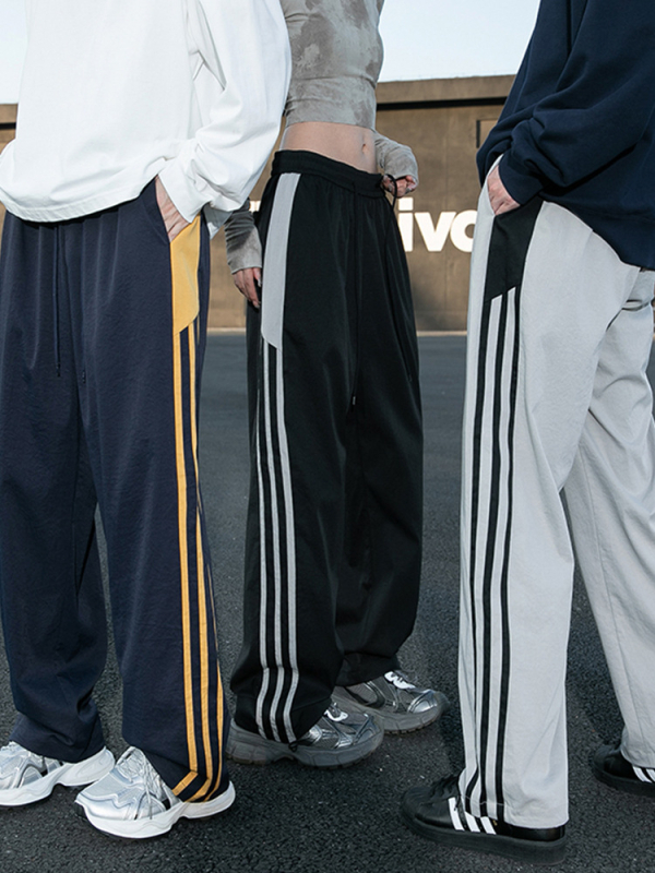 Meeste vabaajarõivaste püksid kontrastsete triipudega, kõrge vöökoht, lai lõige, nööriga kinnituv sulgemine, fleece vooder