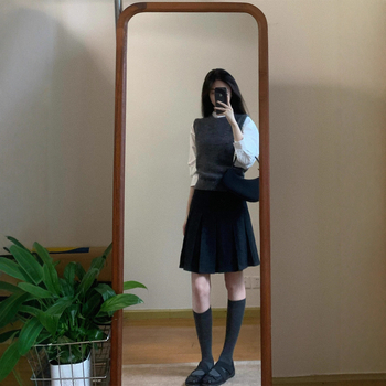 Trojdielny kostým: pletený vest, vrstvená košeľa a vysokopásová A-linijová plisovaná sukňa; jednofarebný vzor, stredná dĺžka sukne, retro štýl