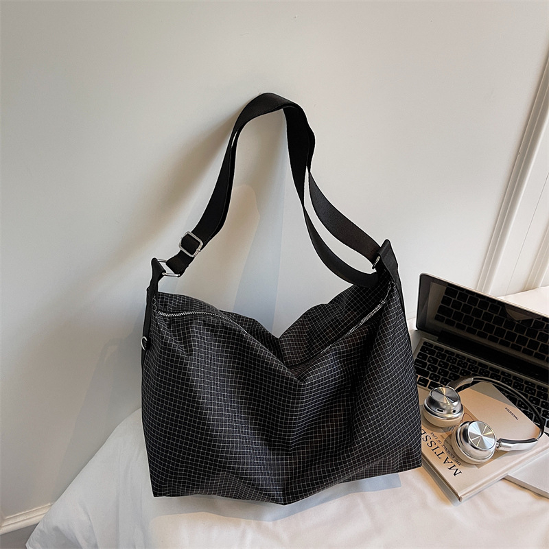 Geantă crossbody cu design în carouri, capacitate mare, din material Oxford, căptușeală din nailon, închidere cu fermoar, buzunar intern laminat.