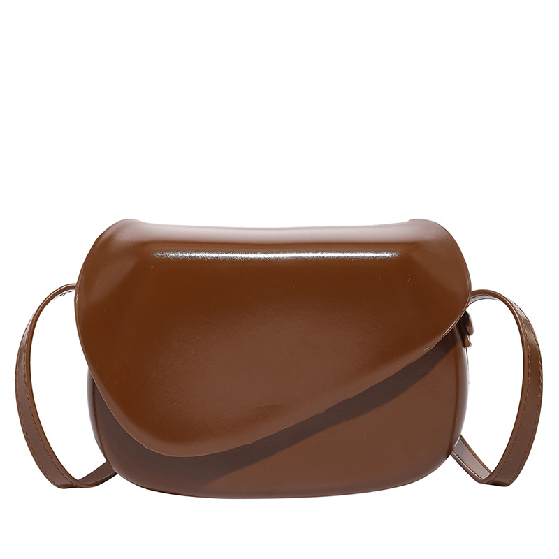 Crossbody soma ar asimetrisku pārklājuma vāciņu un kvadrātveida formu — PU materiāls, poliesteru oderējums, aizvērums ar pārklājošu vāciņu, iekšējie nodalījumi telefoniem un ID, viena pleca siksna