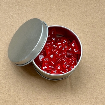 25 caurspīdīgu, daudzpusīgu četrpusīgu spēļu kauliņu iepakojums metāla kastītē, jauns pārrobežu produkts.