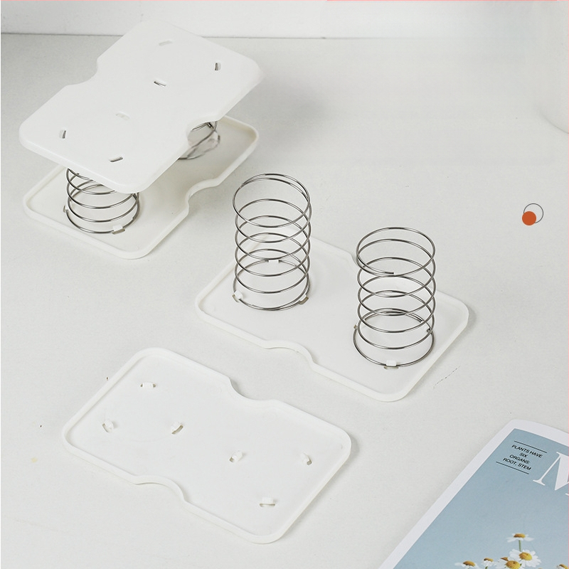 Pakeliama servetėlių dėžutės spyruoklinė atrama, skirta pritraukti prie apatinės spyruoklinės stalčiaus dėžutės apatinės atramos, laikymo dėžutės spyruoklinė lapo pakėlimo elastinė atrama