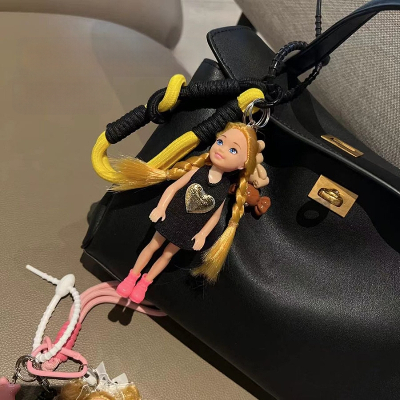 Tarpvalstybinis Jiang Paris ponia Yesha su mielu Barbie lėlės krepšiu ir pakabuku ant automobilio, raktų pakabuku ant riešo.