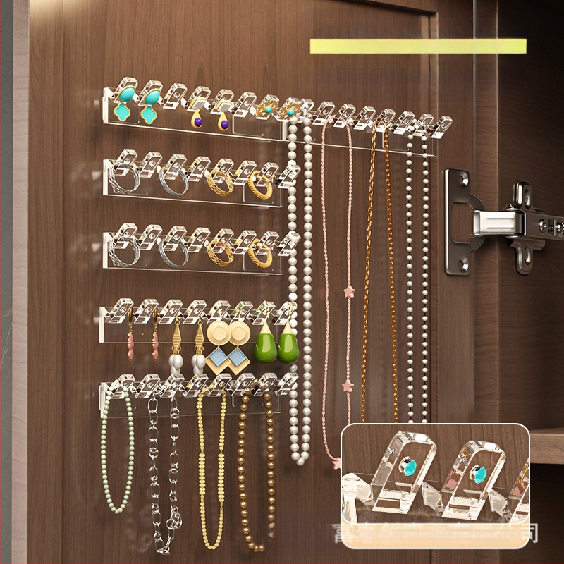 Veidrodinės spintelės durelių gale pakabinama grandinėlės laikymo lentynėlė, rankų grandinėlė, auskarai, sujungti eiliniai kabliukai, apsaugantys nuo susivėlimo, prie sienos tvirtinamas papuošalų stovas be gręžimo