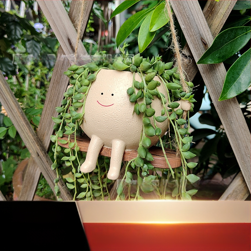 Derva s vazonėlis su šypsena ant sūpynės — WePlus; Medžiaga: derva; Gamybos procesas: dervos apdorojimas; Dovana tinkama