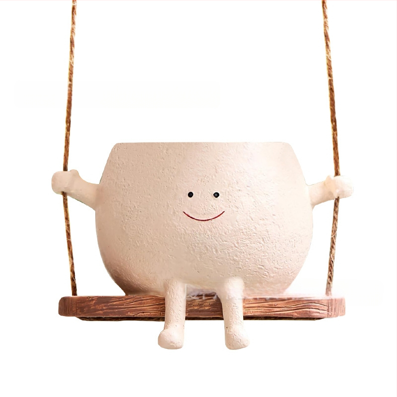 Derva s vazonėlis su šypsena ant sūpynės — WePlus; Medžiaga: derva; Gamybos procesas: dervos apdorojimas; Dovana tinkama