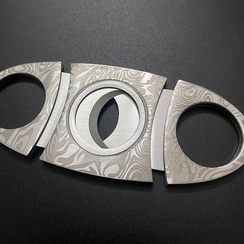 Cigares griezējs no nerūsējoša tērauda ar reljefa rakstu, dubulta asa, pārnēsājams (nerūsējošs tērauds; reljefa raksts; dubulta asa)