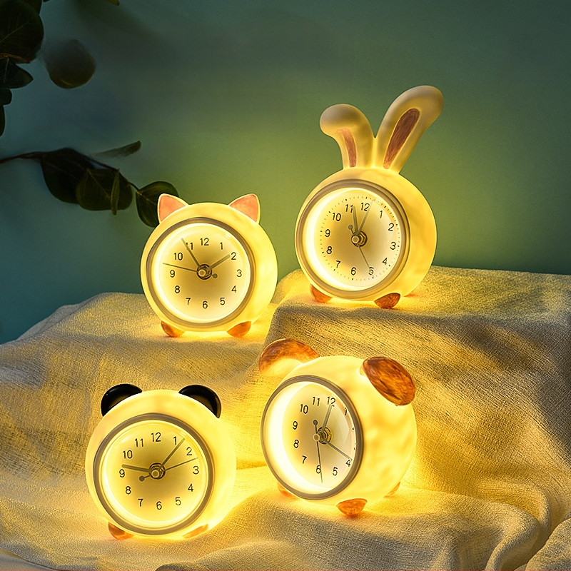 Vaikų stalo laikrodis su taupymo dėžute ir naktiniu apšvietimu, baterijomis maitinamas mechaninis judesys, vienpusis plastikinis korpusas, animacinio stiliaus