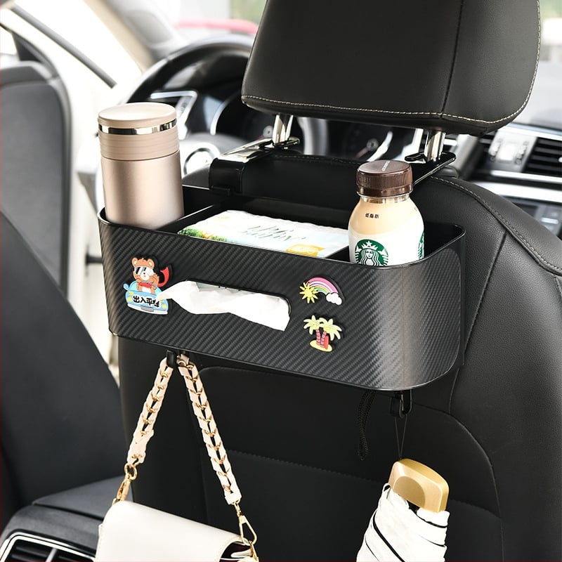Automobilio servetėlių dėžutė — daugiafunkcinis galinės sėdynės organizatorius su puodelio laikikliu ir kabliuku; plastikas, vidutinio dydžio modelis, tinkamas plokščioms servetėlėms