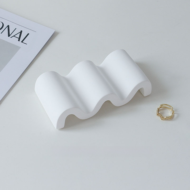 Gipses fons produktu fotografēšanai – minimālistisks viļņots nestandarta kāpņu dizains