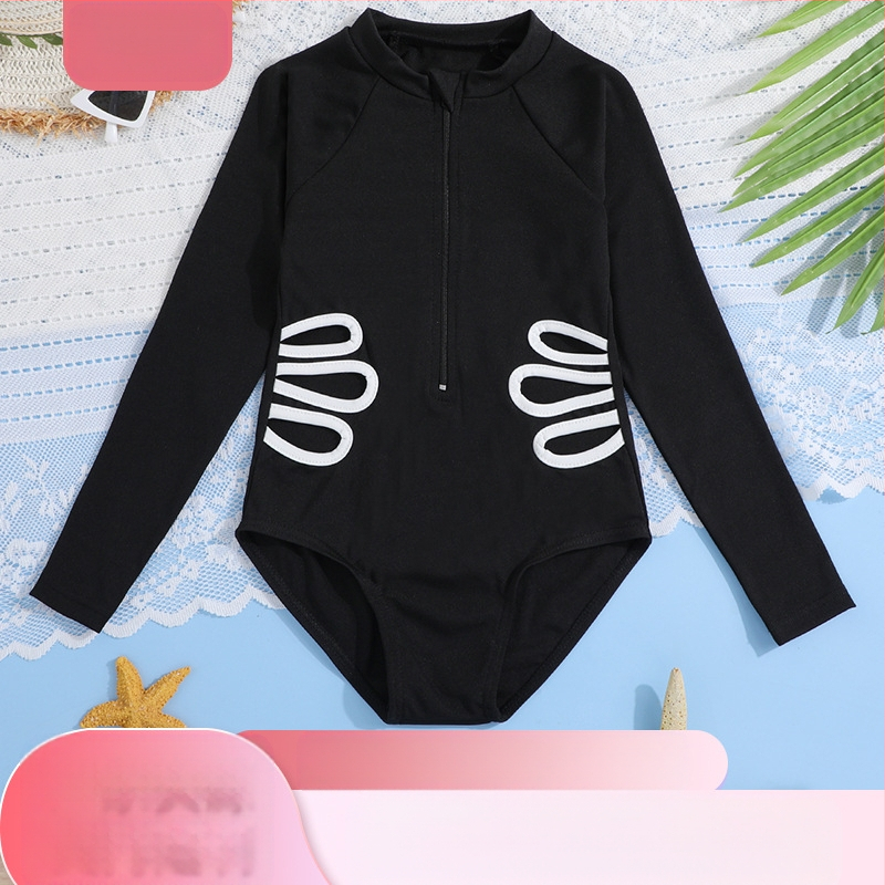 Meitenēm viengabala peldkostīms ar garām piedurknēm un rāvējslēdzēju, adīta auduma materiāls; sastāvs 95% poliesters, 5% spandeks; oderējums poliesters.