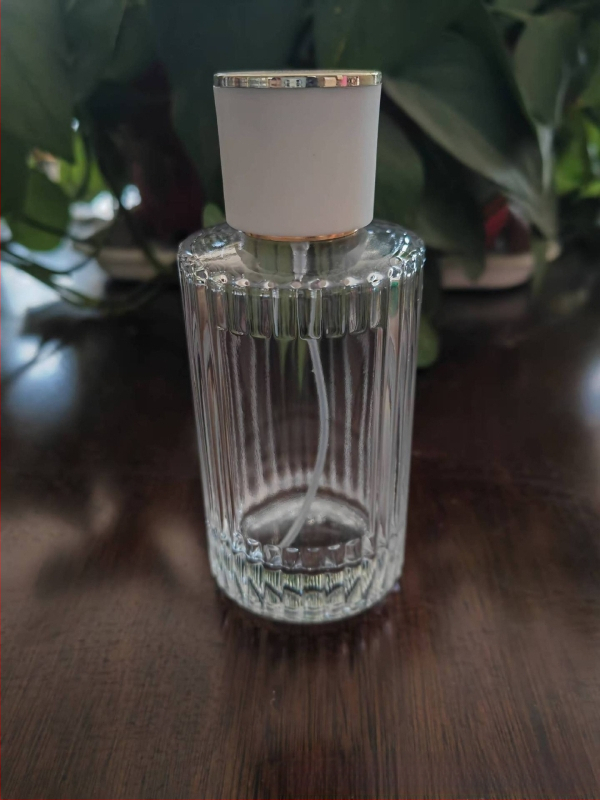 Стъклена бутилка за парфюм със винтово гърло, кръгло прозрачно тяло, дебело вертикално ивично стъкло, голям страничен спрей, тежък капак