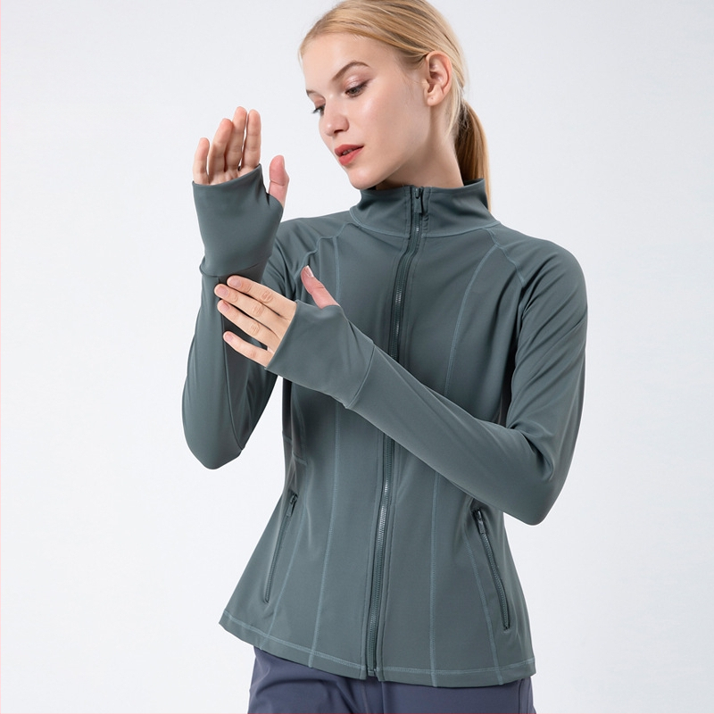 Moteriška sportinė striukė jogos ir bėgimui – greitai džiūstanti, stovinti apykaklė, ilgos rankovės; audinys: nailonų mišinys 75% + Lycra 25%; pamušalas: Lycra 25%; be gobtuvo.