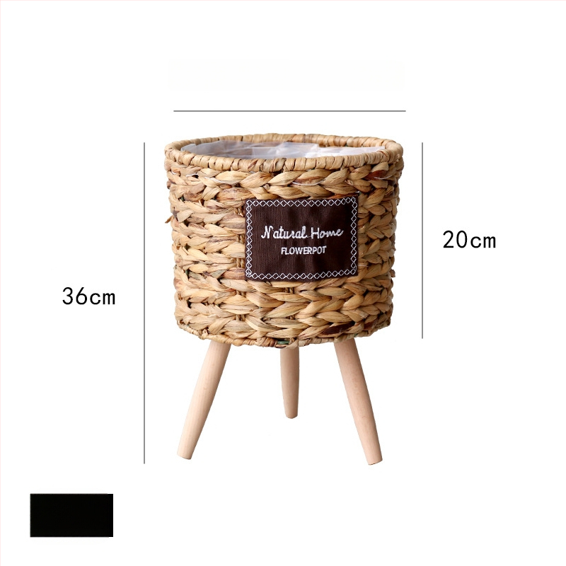 Rataninis gėlių krepšelis ant medinio aukšto grindų stovo vidaus interjerui, kvėpuojantis ir patvarus