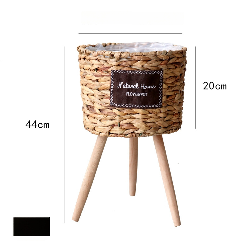 Rataninis gėlių krepšelis ant medinio aukšto grindų stovo vidaus interjerui, kvėpuojantis ir patvarus