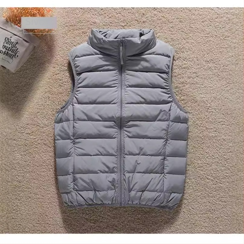 Ženski tanki down jakna-vest s uspravnim ovratnikom i zatvaračem, punjenje kačjim perjem, slim kroj, duljina 50–65 cm.